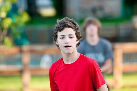 Teenage boy close-up in backyard with expression on face.の写真素材