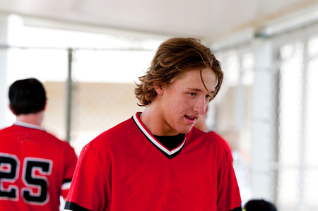 Closeup of baseball player with long hair smiling in dugout.の写真素材