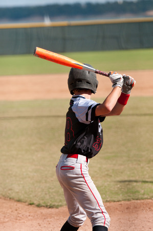 Teenage player getting ready to swing the bat and hit the ball.の写真素材