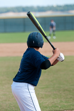 Youth baseball player up at bat in blue jersey.