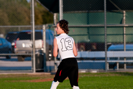 Young kids showing teamwork playing 7 on 7 american football at dusk.の写真素材