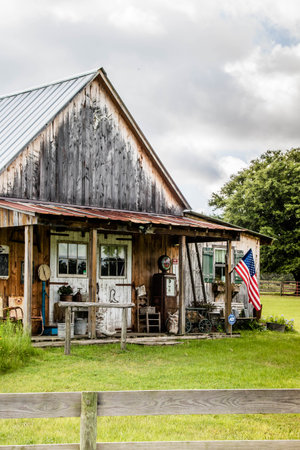Abandoned old wooden house with American flag in the foregroundの写真素材
