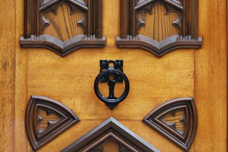 An ornate knocker on a vintage wooden door.の写真素材