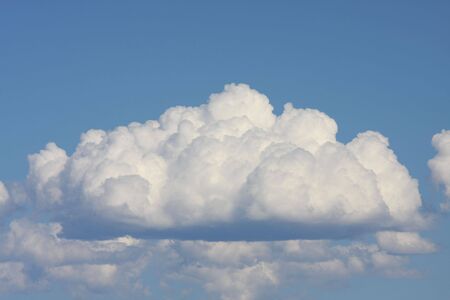 A fluffy cloud with a blue sky background