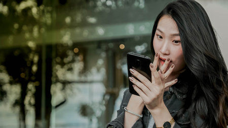 Beautiful young asian woman using smart phone in the city.