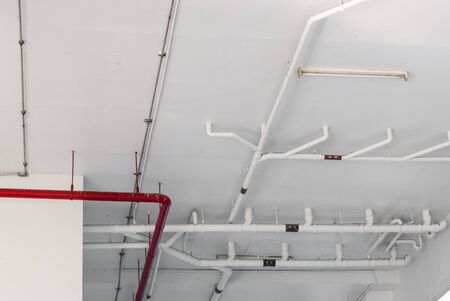 Red and White Pipes under Ceiling in Buildingの写真素材