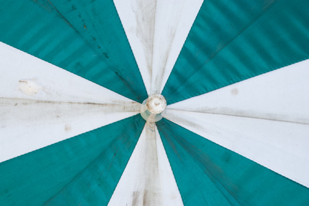 Closeup to Old Stain White and Green Umbrellaの写真素材