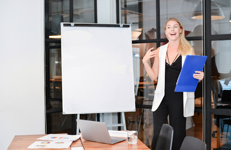 Business blonde woman presenting a project on blank whiteboardの写真素材