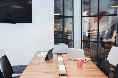 Meeting room with laptops and tablet in business concept, mock up