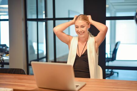 Business blonde girl using a laptop in an officeの写真素材