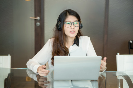 An Asian business woman using laptop in officeの写真素材