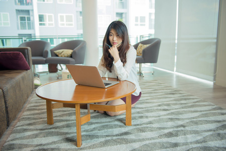 An Asian sexy business woman using a laptop in libraryの写真素材