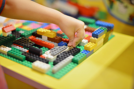 Little boy playing plastic blocks construction indoorの写真素材