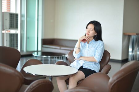 Asian business woman thinking in modern living roomの写真素材