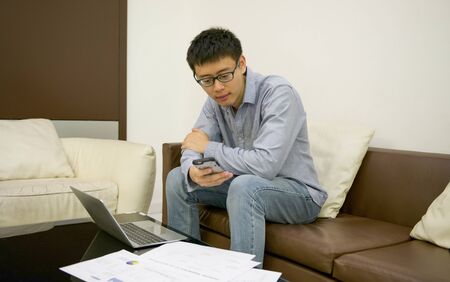 Asian businessman using a laptop in living room at nightの写真素材