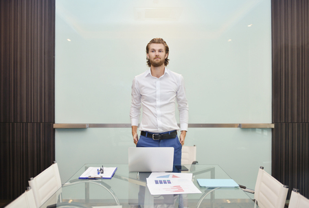 Blonde business man presenting a project on blank glass boardの写真素材