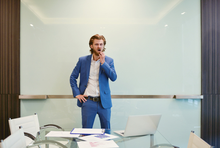 Blonde business man presenting a project on blank glass boardの写真素材
