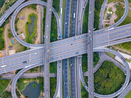 Aerial view of cars driving on highway junctions. Bridge roads with green garden and trees in connection of architecture concept. Top view. Urban city, Taipei, Taiwan.の写真素材