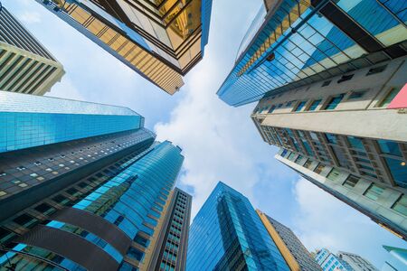 Looking up to high-rise office buildings, skyscrapers, architectures in financial district. Smart urban city for business and technology concept background in Downtown Hong Kong, China.の写真素材