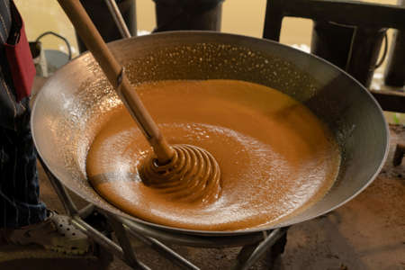 Asian man making boiled palm coconut sugar or cane production process, raw material, Amphawa, Thailand. Traditional culture lifestyle. Local sweet food.の写真素材