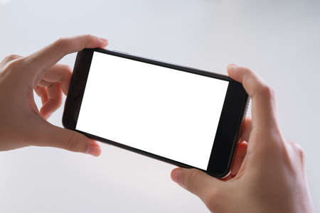hands holding a smart phone device with blank empty screen isolated on white background. Technology....