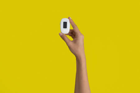 Hand with pulse oximeter or blood oxygen level measure monitor device with display isolated on...