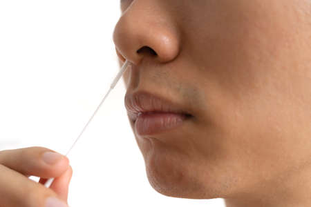 Close up Asian man with a Nasopharyngeal Nose Swab Specimen. Antigen or Antibody test. Virus disease healthcare check.の写真素材