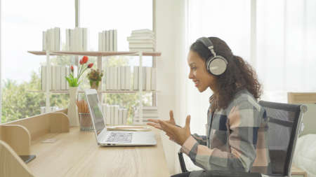Portrait of happy smiling business, latin woman working from home, people talking on webcam video meeting, call conference, working online in quarantine in bedroom at home. Lifestyle. Webinarの写真素材