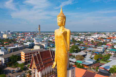 Aerial view of standing buddha statue in temple from above. Top view. Real estate in Roi et province city, Thailand. Property real estate.の写真素材