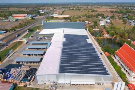 Aerial view of solar panels or solar cells on the roof of factory building rooftop. Power plant, renewable clean energy source. Eco technology for electric power in industry.の写真素材
