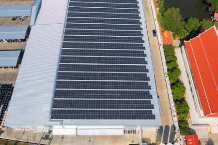 Aerial view of solar panels or solar cells on the roof of factory building rooftop. Power plant,...