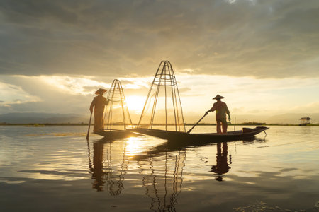 Burmese fisherman casting or throwing a net for catching freshwater fish in Unle lake, natural river in Asia in Myanmar. People lifestyle.の写真素材