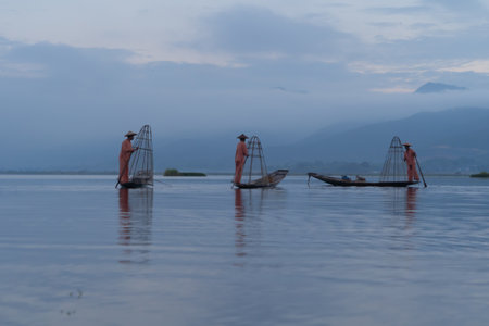 Burmese fisherman casting or throwing a net for catching freshwater fish in Unle lake, natural river in Asia in Myanmar. People lifestyle.の写真素材