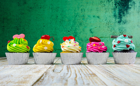 Colorful cupcakes on a wooden backgroundの写真素材