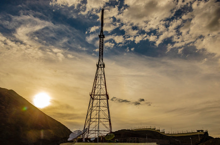 Telecommunication towers with TV antennas and satellite dish on blue sky backgroundの写真素材