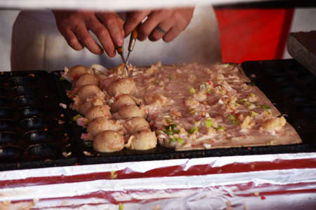 Takoyaki, which is often seen at Japanese festival stalls, is a snack made by putting octopus and condiments in flour dough and baking it in a ball shape.の写真素材