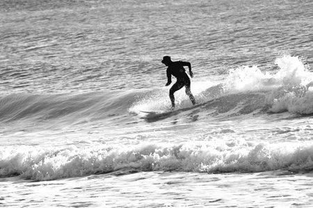 Surfers on the beach on a winter morning. Sports background material.