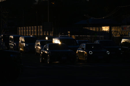 Silhouette of a cityscape at dusk. The sunset clouds and the silhouette of cars returning home and...
