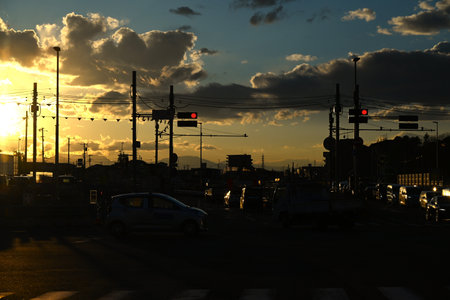 Silhouette of a cityscape at dusk in Japan. The sunset clouds and the silhouette of cars returning...