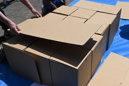 Disaster prevention drill. Assembling a cardboard bed for evacuation shelters. The floor of the evacuation shelter is hard and cold, so this bed allows get a good night's sleep.の写真素材