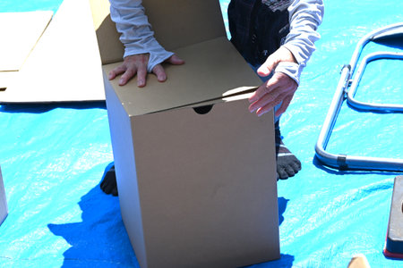 Disaster prevention drill. Assembling a cardboard bed for evacuation shelters. The floor of the evacuation shelter is hard and cold, so this bed allows get a good night's sleep.の写真素材