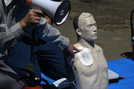 Lifesaving training using an AED. It is effective in helping the heart regain normal function by delivering an electric shock to the heart from outside the body.の写真素材