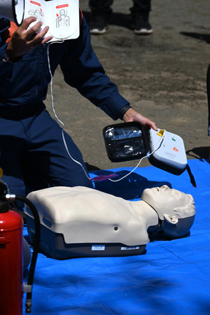 Lifesaving training using an AED. It is effective in helping the heart regain normal function by delivering an electric shock to the heart from outside the body.の写真素材