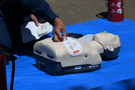 Lifesaving training using an AED. It is effective in helping the heart regain normal function by delivering an electric shock to the heart from outside the body.の写真素材