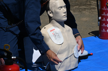 Lifesaving training using an AED. It is effective in helping the heart regain normal function by delivering an electric shock to the heart from outside the body.の写真素材
