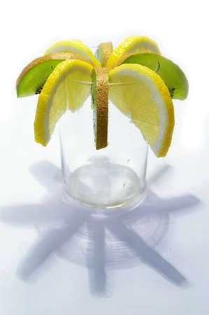 parts of lemon and kiwi in the glass on white backgroundの写真素材