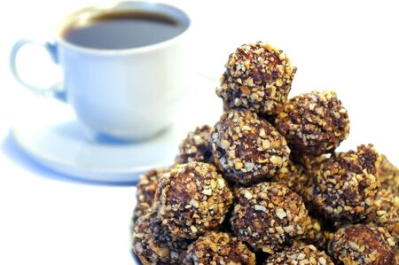 chocolate sweets whith nuts and white cup of coffeeの写真素材