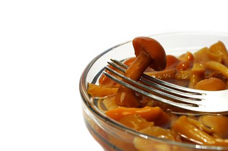 Mushroom in marinade on a plug on a white backgroundの写真素材