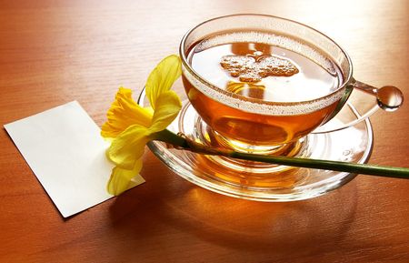 Cup of black tea and flowers narcissusesの写真素材
