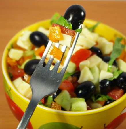 The Greek salad in a bright ceramic plateの写真素材